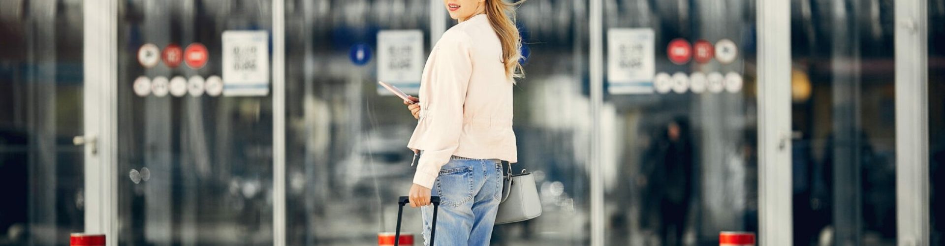 Girl in a airport. Blonde with a documents. Lady in a black t-shirt